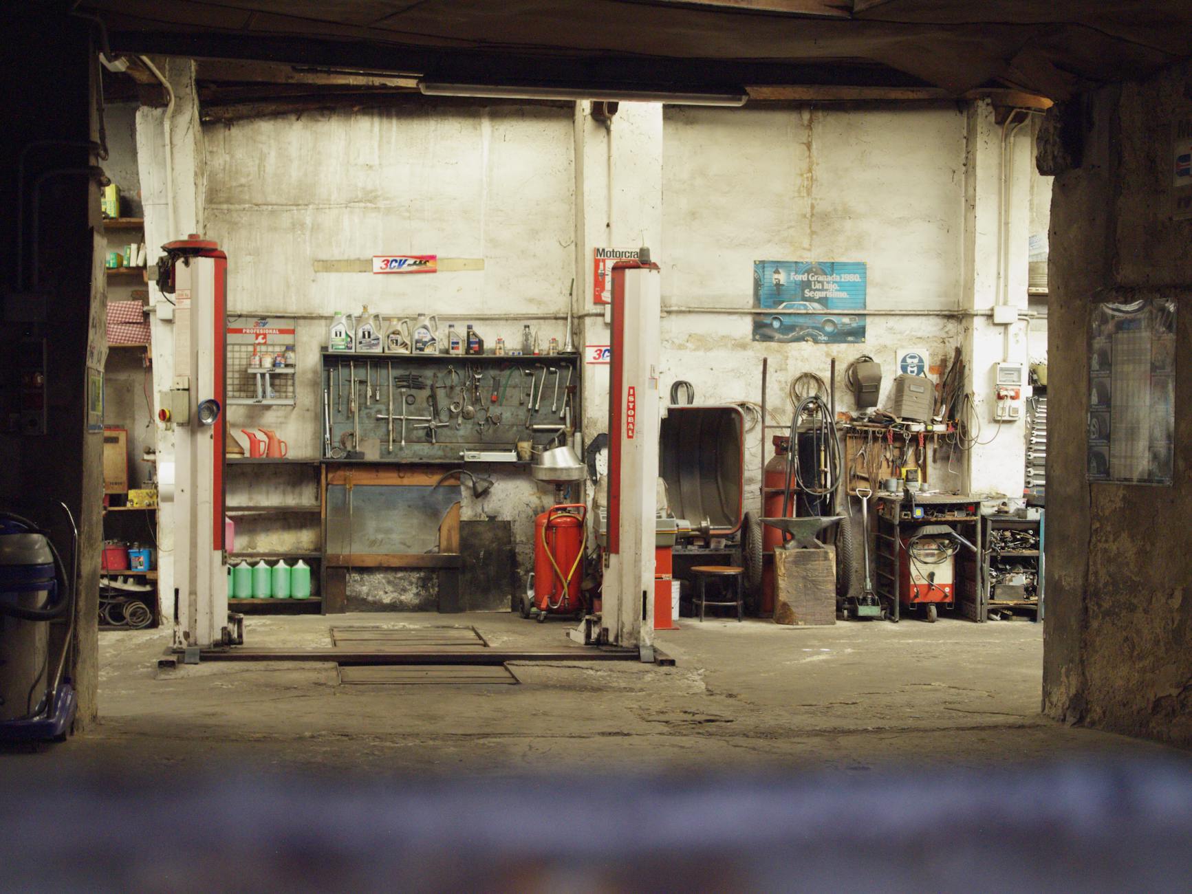 Pusty, industrialny warsztat samochodowy z podnośnikami i narzędziami